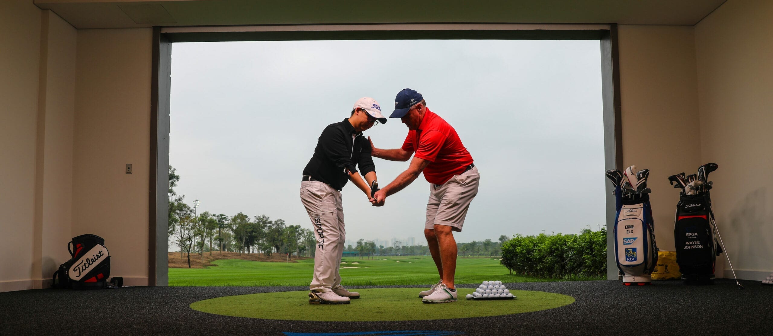 instructor directing a student as they take a swing on golf course