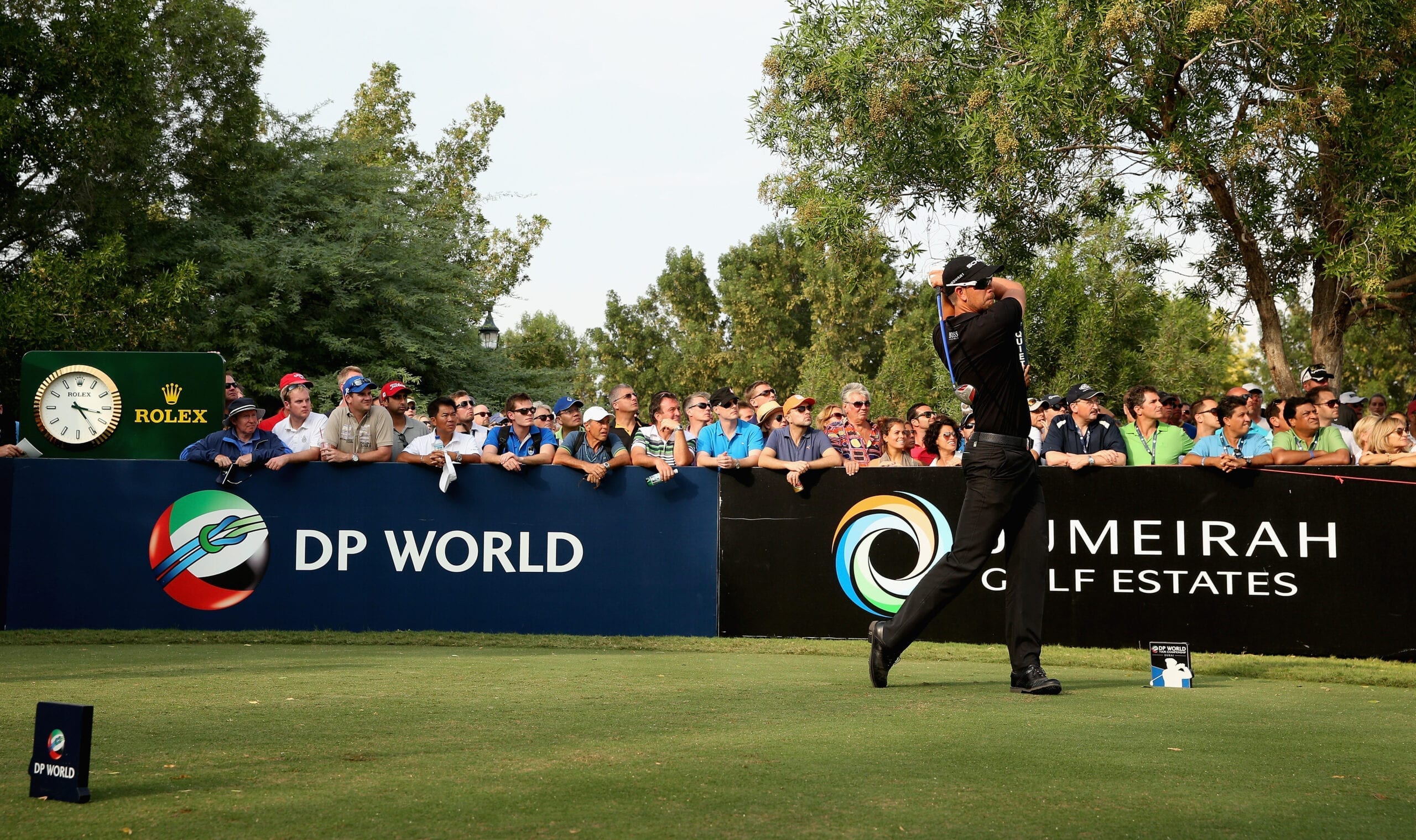 player taking a swing at a golf tournament as audience looks on